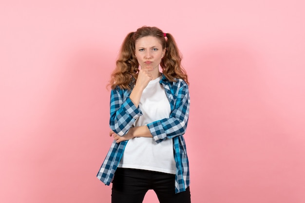 Vista frontale giovane femmina in camicia a scacchi in posa e pensando su sfondo rosa gioventù donna colore emozioni modello bambino