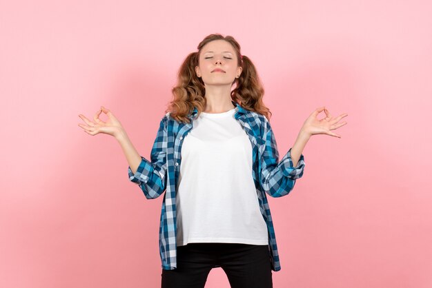 Vista frontale giovane femmina in camicia a scacchi in posa su rosa scrivania modello gioventù donna emozione kid colore