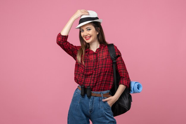 Vista frontale giovane femmina in camicia rossa con cappello su sfondo rosa colore donna umana