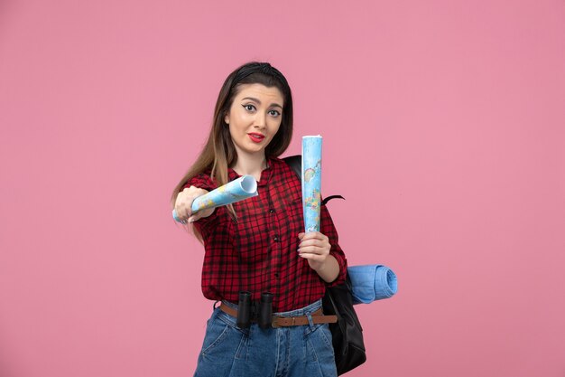 Vista frontale giovane femmina in camicia rossa con mappe su donna umana di colore rosa scrivania