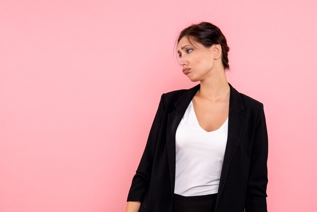 Vista frontale giovane femmina in giacca scura sottolineato su sfondo rosa