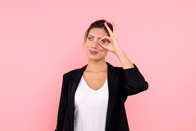 Vista frontale giovane femmina in giacca scura su sfondo rosa