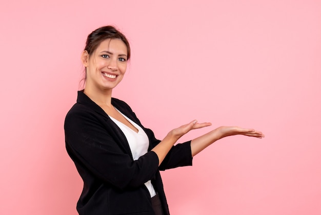 Vista frontale giovane femmina in giacca scura su sfondo rosa