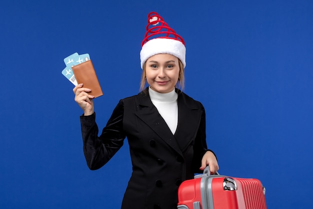 Vista frontale giovane femmina in possesso di biglietti con borsa su sfondo blu donna vacanza vacanza