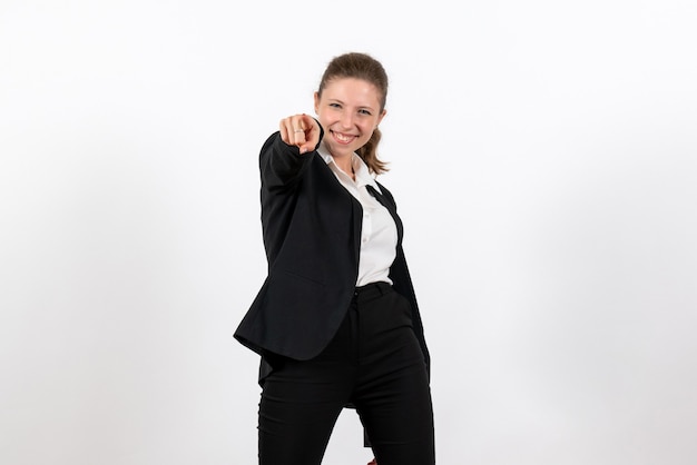 Vista frontale giovane femmina in rigoroso abito classico in posa su sfondo bianco chiaro lavoro donna vestito di affari lavoro femminile