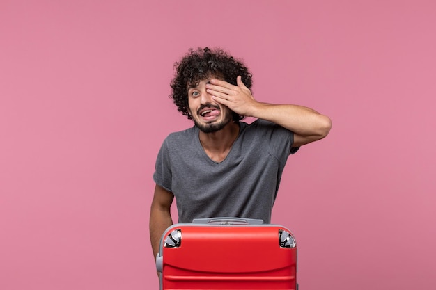 Vista frontale giovane maschio che copre metà della sua faccia su uno spazio rosa pink