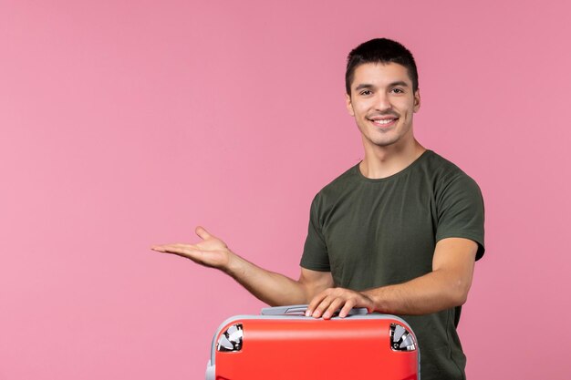 Vista frontale giovane maschio che si prepara per le vacanze e si sente felice nello spazio rosa