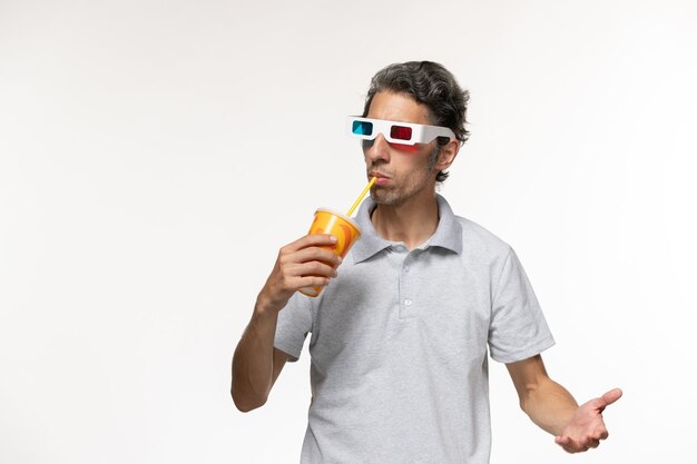 Vista frontale giovane maschio che tiene soda e indossa occhiali da sole d sul muro bianco uomo film solitario remoto