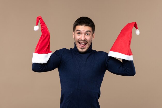 Vista frontale giovane maschio con berretti rossi, emozione vacanza di natale