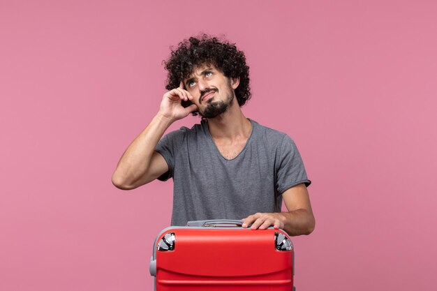 Vista frontale giovane maschio con borsa rossa che si prepara per il viaggio nello spazio rosa