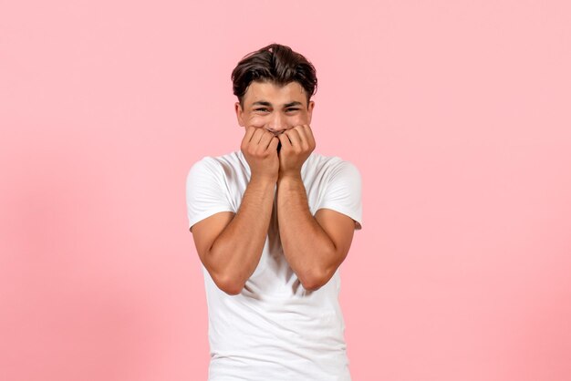 Vista frontale giovane maschio nervoso in maglietta bianca sulla parete rosa modello di colore maschile emozione