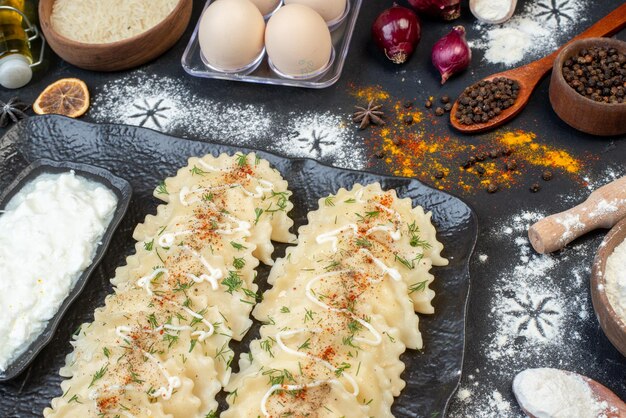 Vista frontale gnocchi di carne cucinati con ingredienti diversi su sfondo scuro piatto di verdure che cucinano la cena a base di pasta colorata