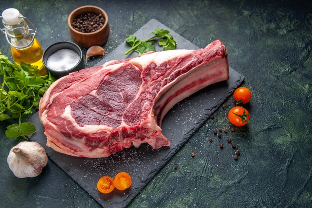 Vista frontale grande fetta di carne carne cruda con pepe e verdure su foto scura farina di pollo animale barbecue macellaio di cibo