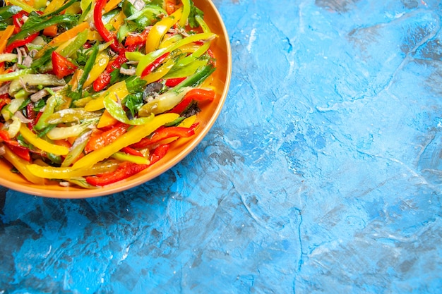 Vista frontale gustosa insalata di verdure all'interno del piatto sul tavolo blu