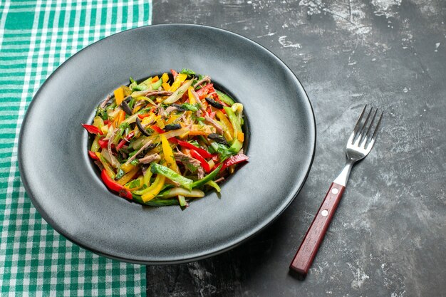 Vista frontale gustosa insalata di verdure all'interno del piatto sul tavolo grigio