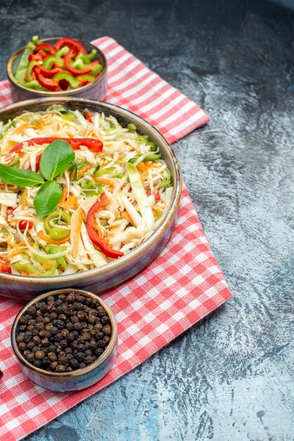 Vista frontale gustosa insalata di verdure con cavolo a fette e peperoni sul tavolo grigio