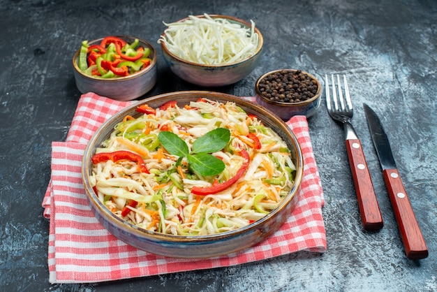 Vista frontale gustosa insalata di verdure con cavolo a fette e peperoni sul tavolo grigio