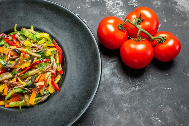 Vista frontale gustosa insalata di verdure con pomodori freschi sul tavolo grigio chiaro