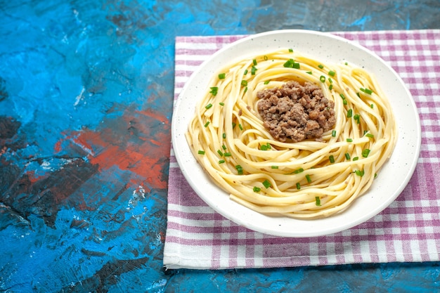 Vista frontale gustosa pasta italiana con carne macinata su cibo per piatti di pasta di colore blu