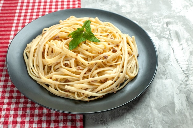 Vista frontale gustosa pasta italiana su pasta di colore alimentare per foto bianca