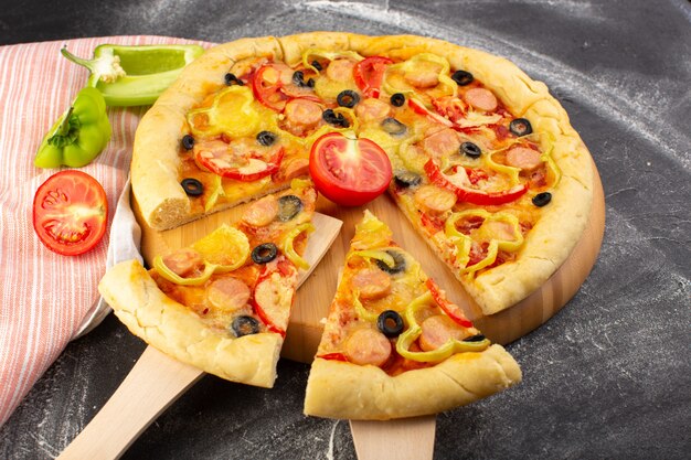 Vista frontale gustosa pizza di formaggio con pomodori rossi olive nere peperoni e salsicce su grigio