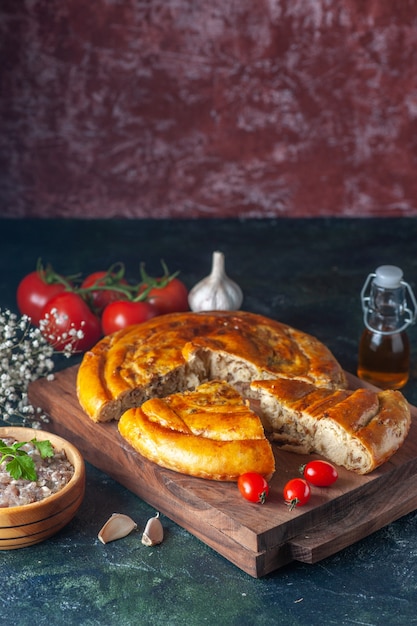 Vista frontale gustosa torta di carne con verdure e pomodori su sfondo scuro torta di biscotti cibo cuocere pasta colorata torta al forno