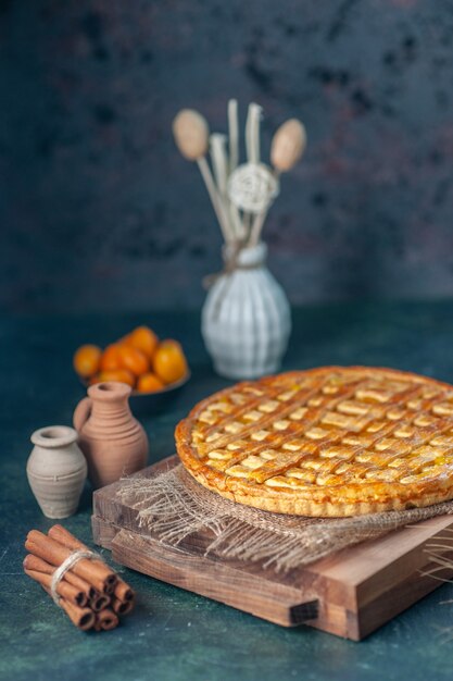 vista frontale gustosa torta kumquat su sfondo blu scuro