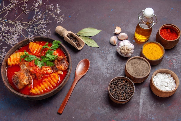 Vista frontale gustosa zuppa di carne con condimenti su salsa di cena di cibo zuppa di superficie scura