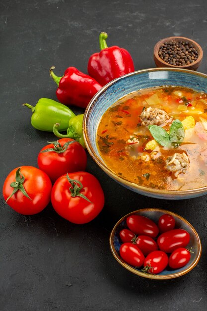 Vista frontale gustosa zuppa di carne con verdure fresche su uno sfondo scuro