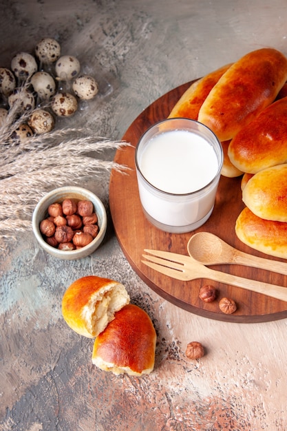 Vista frontale gustose focacce al forno con bicchiere di latte