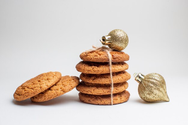 Vista frontale gustosi biscotti dolci su biscotto bianco dessert tè foto torta zucchero