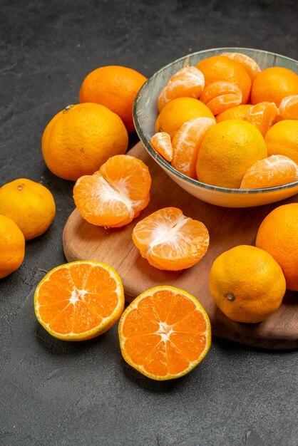 Vista frontale gustosi mandarini succosi all'interno del piatto sullo sfondo grigio agrumi esotici foto a colori arancia acida