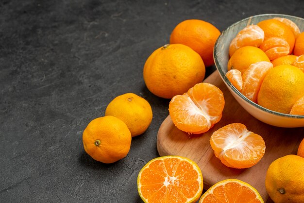Vista frontale gustosi mandarini succosi all'interno del piatto sullo sfondo grigio agrumi esotici foto a colori arancia acida