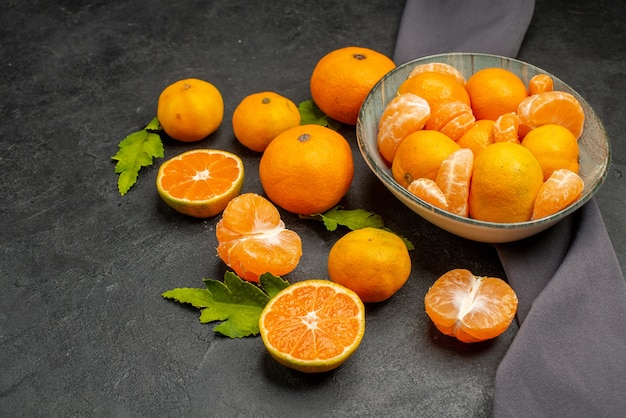 Vista frontale gustosi mandarini succosi su uno sfondo scuro colore acido foto esotica frutta arancione agrumi