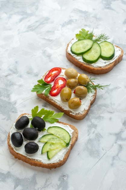 Vista frontale gustosi panini con cetrioli e olive sfondo bianco pranzo sandwich pasto orizzontale hamburger pane pane tostato