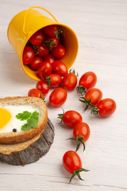 Vista frontale gustosi toast all'uovo con pomodori su sfondo bianco cibo foto a colori pasto mattutino pranzo insalata