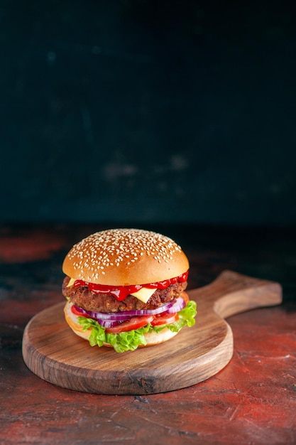 Vista frontale gustoso cheeseburger di carne su superficie scura