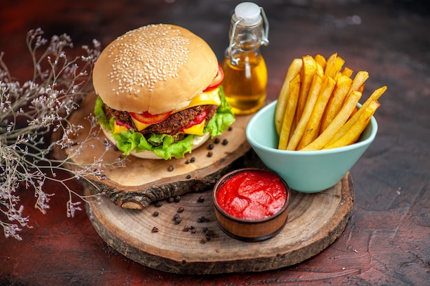 Vista frontale gustoso hamburger di carne con patatine fritte su sfondo scuro