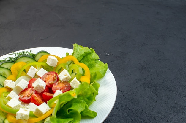 vista frontale insalata di verdure è composta da cetrioli affettati pomodori pepe e formaggio su sfondo scuro