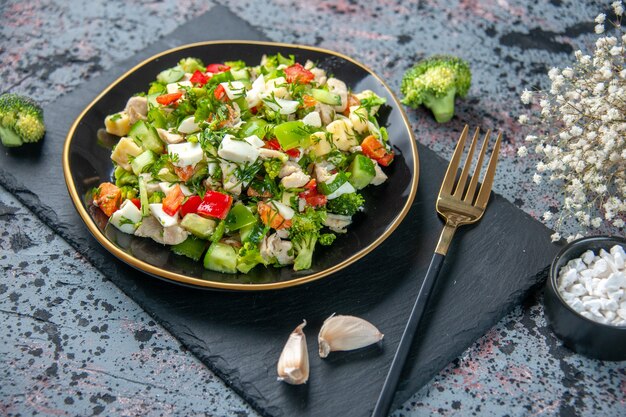 vista frontale insalata di verdure è composta da cetriolo formaggio e pomodori all'interno del piatto su sfondo scuro