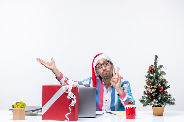 Vista frontale lavoratore maschio seduto nel suo posto di lavoro lavoro emozione natalizia business