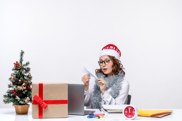 Vista frontale lavoratrice seduta davanti al suo posto di lavoro facendo aeroplani di carta lavoro lavoro emozione affari ufficio natale