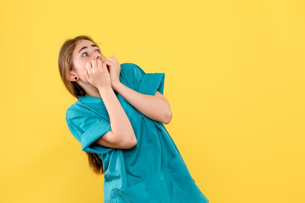 Vista frontale medico femminile spaventato su sfondo giallo salute medico ospedale emozione