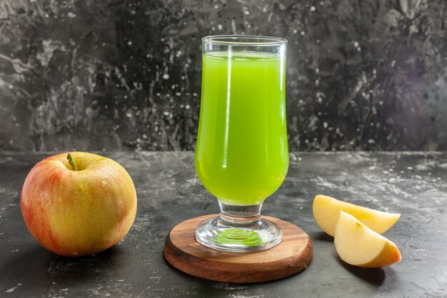 Vista frontale mela matura fresca con succo di mela verde sul colore della foto dell'albero del succo morbido della scrivania scura