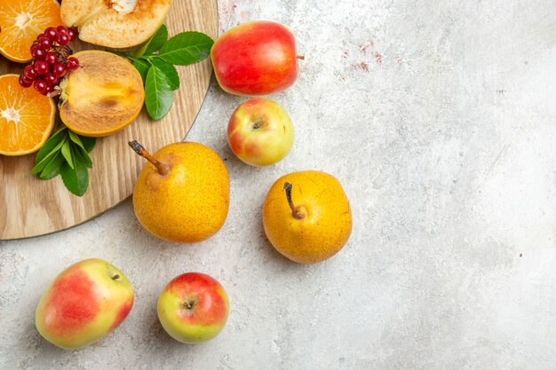 Vista frontale mele cotogne fresche con altri frutti sul tavolo bianco chiaro frutta matura dolce fresca