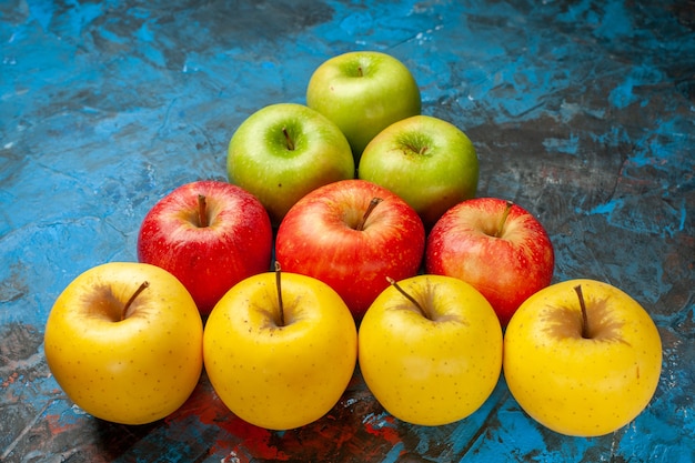 Vista frontale mele dolci fresche allineate come un triangolo su sfondo blu dieta vitamina gustosa salute matura dolce