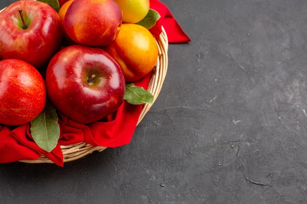 Vista frontale mele fresche all'interno del cesto sul tavolo scuro frutta fresca matura