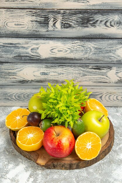 Vista frontale mele fresche con arance a fette su sfondo grigio frutta matura matura mela fresca