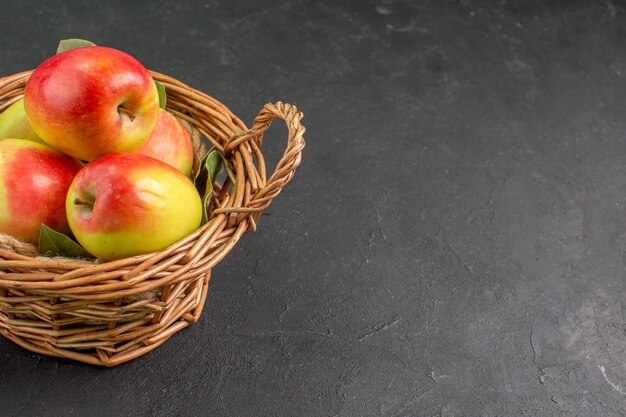 Vista frontale mele fresche frutti maturi all'interno del cesto sulla scrivania grigia frutta fresca matura