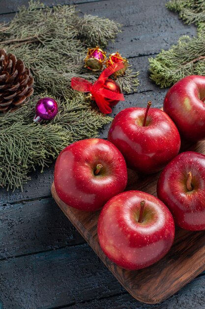 Vista frontale mele rosse fresche frutti maturi dolci su piante da scrivania blu scuro molti colori di frutta vitamina rosso fresco